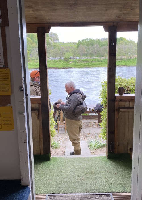 This is the scenery from inside the Newtyle Beat fishing hut in Birnam with the River Tay flowing past only a few yards away. The cobbled area where the fishing guest is standing and the big table behind him is a great area for outdoor lunches during periods of warm dry weather.